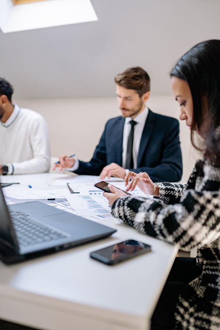 Diverse coworkers collaborating over documents in a bright office setting, fostering teamwork.